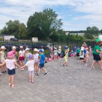 Dzieci tańczące w kółku przed budynkiem Oddziału w Radzanowie