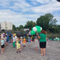 Pracownik Banku rozdający dzieciom balony z logo Banku