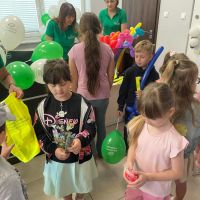 Pracownicy rozdający pamiątkowe gadżety dzieciom