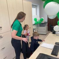 Pracownik Banku pokazujący pracę dziecku na komputerze