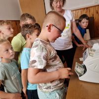 Dzieci próbujące swoich sił w liczeniu banknotów na liczarce