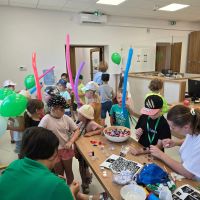 Dzieci częstujące się cukierkami i bawiące się balonami