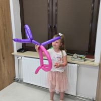 Dziewczynka pozująca z balonem pieskiem wykonanym przez pracowników Banku