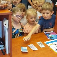 Dzieci próbujące swoich sił w rozpoznawaniu nominałów pieniężnych