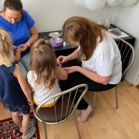 Pracownicy Banku robiący brokatowe tatuaże dzieciom