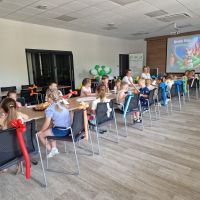 Zdjęcie dzieci siedzących na sali konferencyjnej Banku