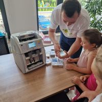 Kasjer Banku pokazujący funkcjonalności liczarki