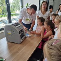 Kasjer Banku pokazujący poszczególne nominały banknotów