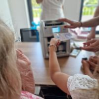 Dzieci wkładające banknoty do liczarki