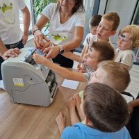 Dzieci próbujące swoich sił w liczeniu banknotów na liczarce