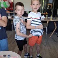 Chłopcy pozujący z wykonanymi na rękach brokatowymi tatuażami