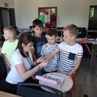 Pracownik Banku wykonujący brokatowy tatuaż na ręku chłopca