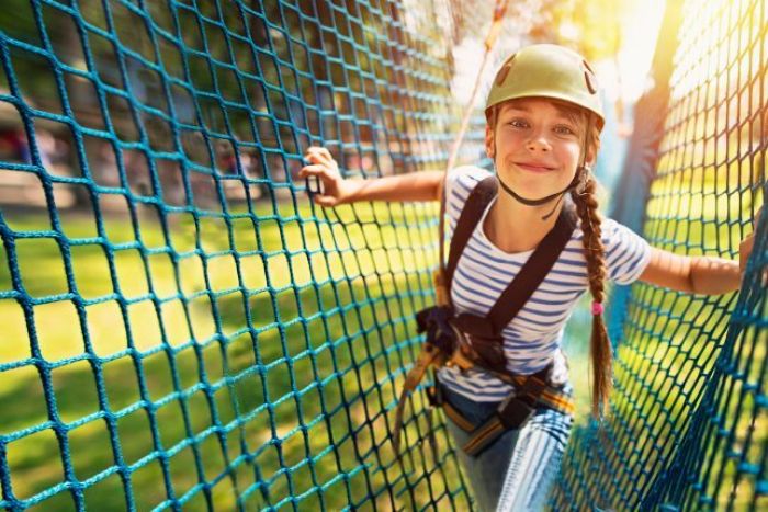 Dziewczynka wspinająca się po linach w kasku ochronnym