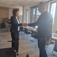 Zastępca Prezesa Zarządu podająca dłoń na przywitanie zaproszonemu gościowi