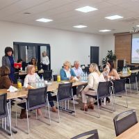 Przedstawiciele Banku witający się z przybyłymi na spotkanie gośćmi