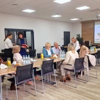 Przedstawiciele Banku witający się z przybyłymi na spotkanie gośćmi