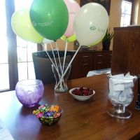 Balony stojące na biurku wraz ze słodyczami i owocami