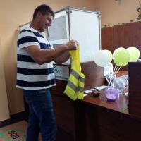Klient Banku otrzymujący prezent w postaci kamizelki odblaskowej z logo Banku
