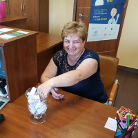 Uśmiechnięta Klientka Banku losująca ze szklanej kuli pytanie z konkursu wiedzy o Banku