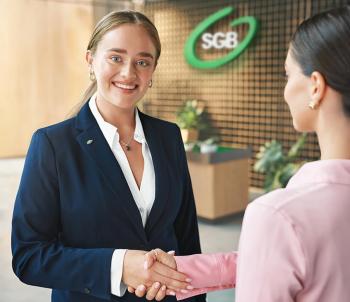 Pracownik Banku ściskający dłoń z uwagi na podjęcie współpracy z Klientem