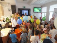 Gromadka dzieci trzymająca kolorowe balony z logo Banku