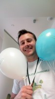 Uśmiechnięty pracownik Banku trzymający balony z logo Banku