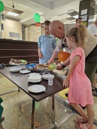 Dzieci częstujące się smakołykami przygotowanymi na Święto Spółdzielczości