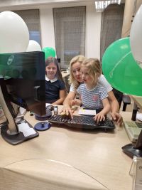 Pracownik Banku pokazujący pracę dziecku na komputerze