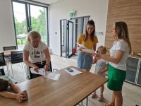 Pracownik Banku wręczający podziękowania dla dzieci za czynny udział w Święcie Spółdzielczości