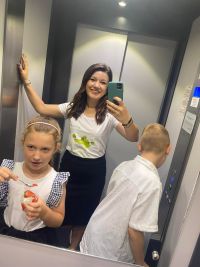 Pracownik Banku zabierający windą dzieci na zwiedzanie Banku